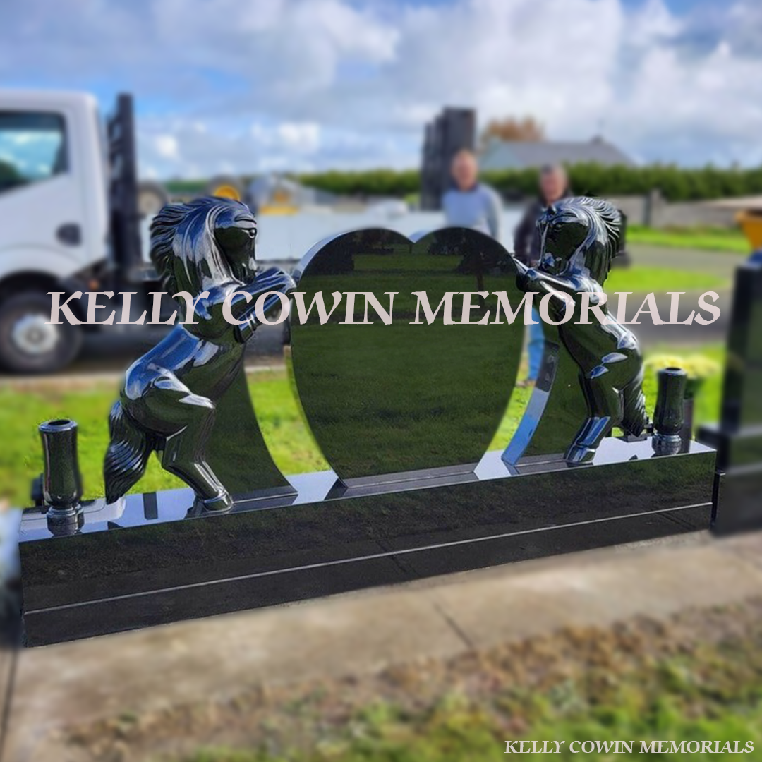 Black granite horse holding heart-shaped memorial headstone with gold engraving and tall vases by Kelly Cowin Memorials Ireland
