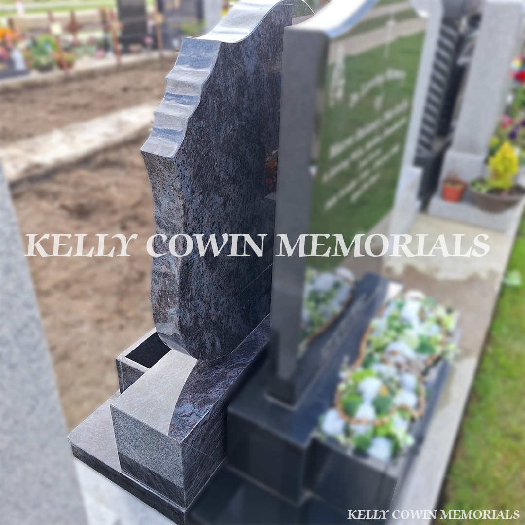 Side view of polished Blue Lagoon shell headstone showing the shaped granite profile, sub-base, base, plinth and integrated flowerbox in Balgriffin Cemetery.