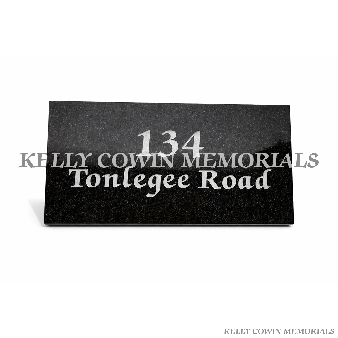 Black granite engraved house plaque mounted on exterior wall in Ireland