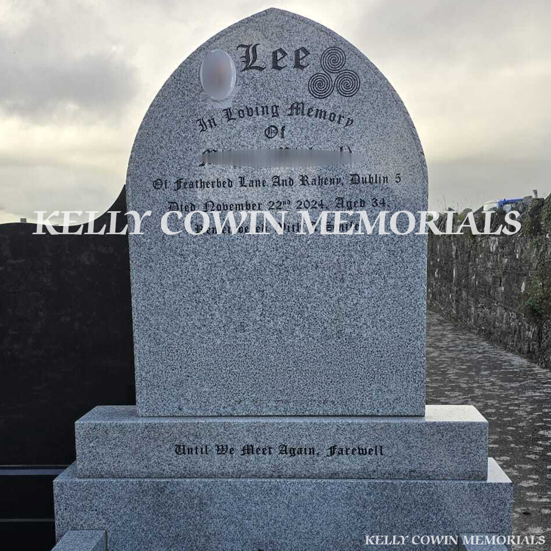 Front close up view of grey granite pointed headstone with kerbing and garden bar