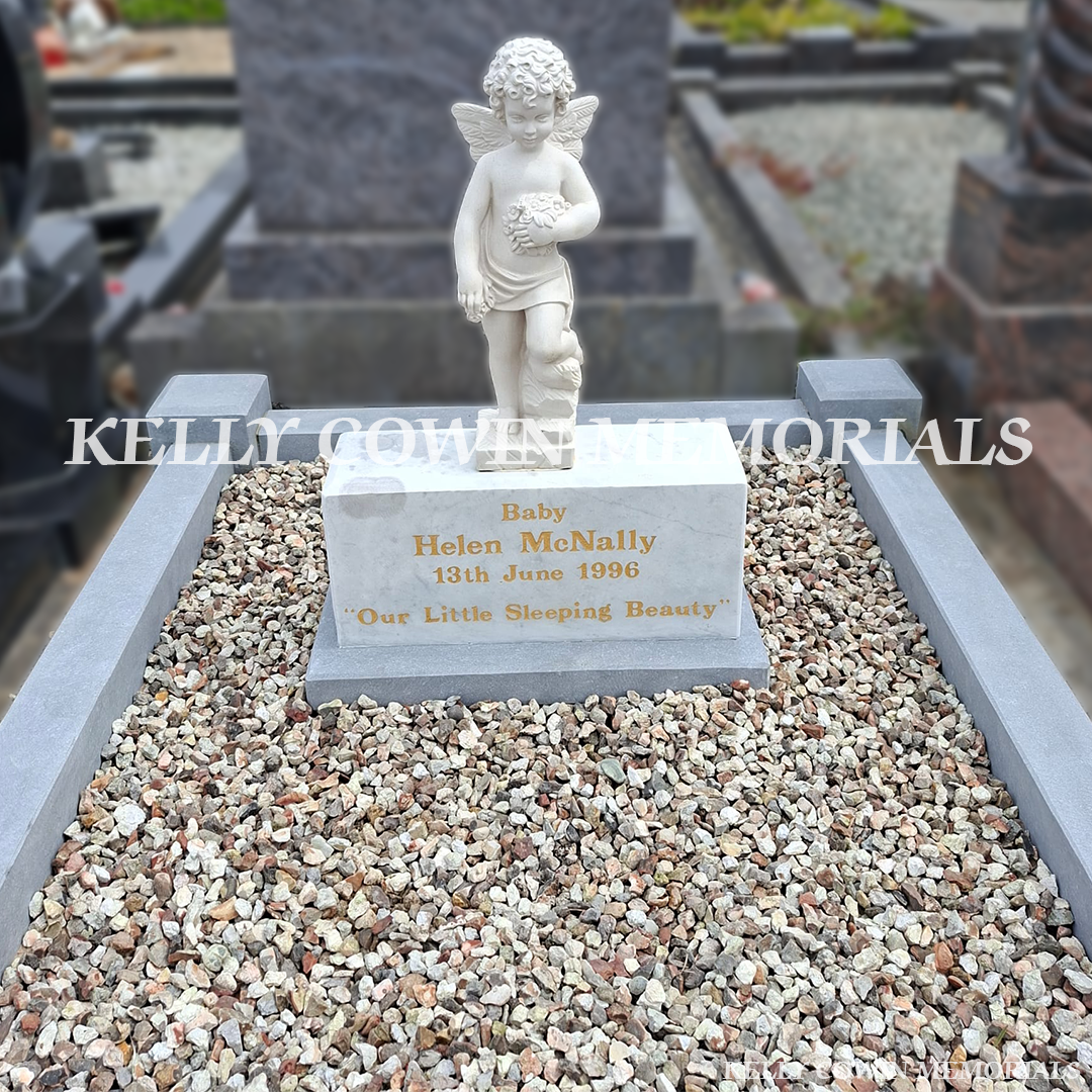 Close-up of restored white marble angel statue and cleaned limestone kerbing