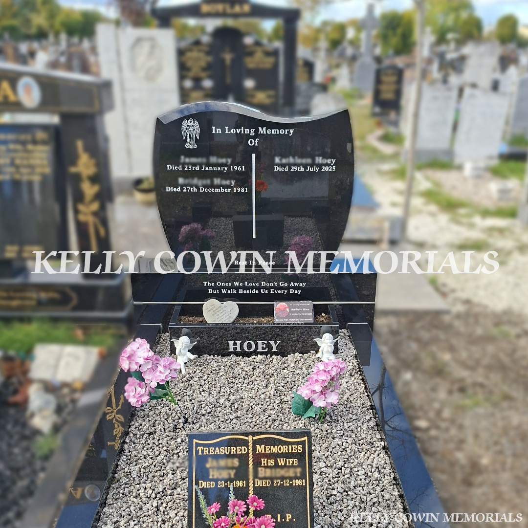 Black granite C1 double plot headstone with curved top, silver engraved inscriptions, matching granite sub-base, base, full grave kerbing, personalised flowerbox and grey-white decorative chippings, erected in Glasnevin Cemetery, Dublin, by Kelly Cowin Memorials.