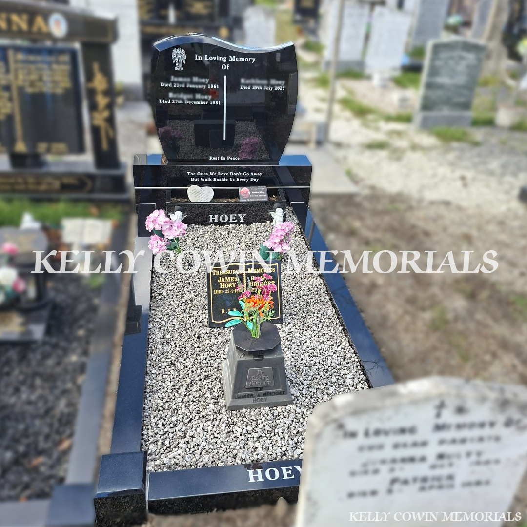 Black granite C1 double plot headstone with curved top, silver engraved inscriptions, matching granite sub-base, base, full grave kerbing, personalised flowerbox and grey-white decorative chippings, erected in Glasnevin Cemetery, Dublin, by Kelly Cowin Memorials.