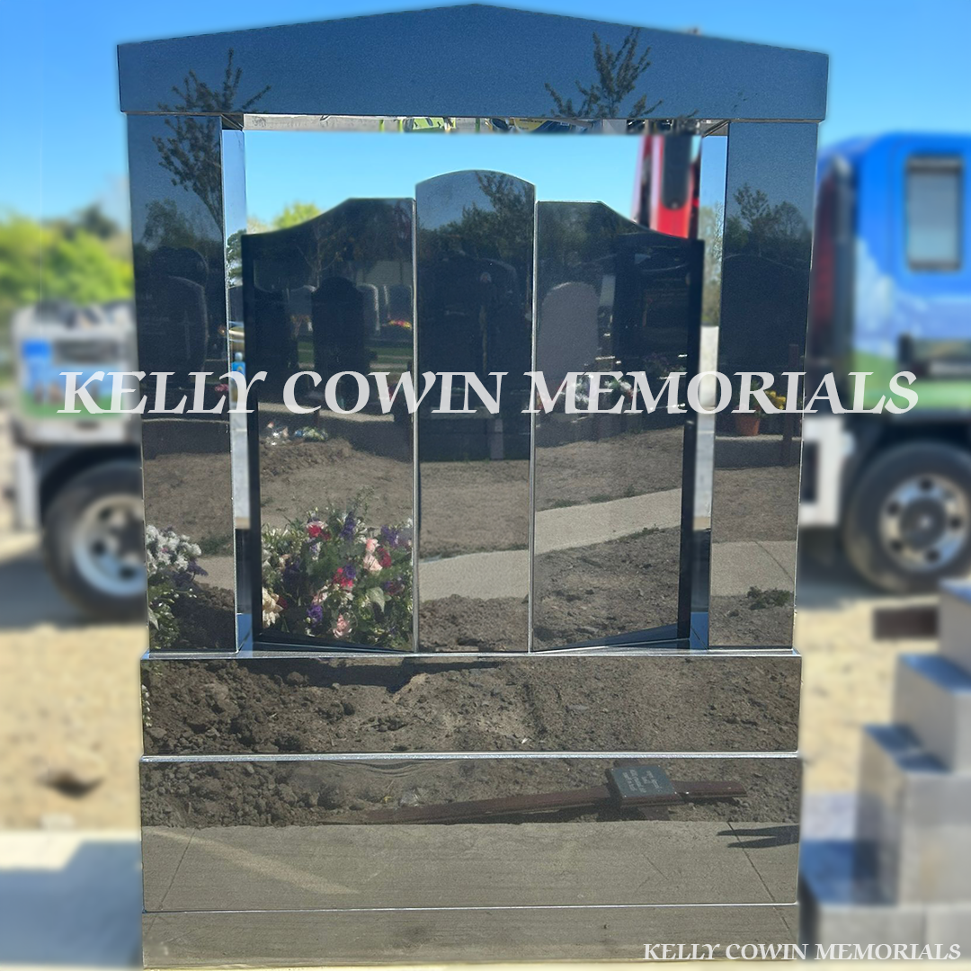 Back view of black granite memorial with square pillars 