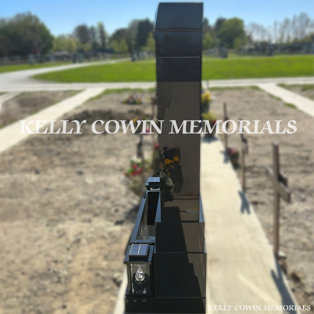 Side view of black granite memorial with square pillars and solar lanterns