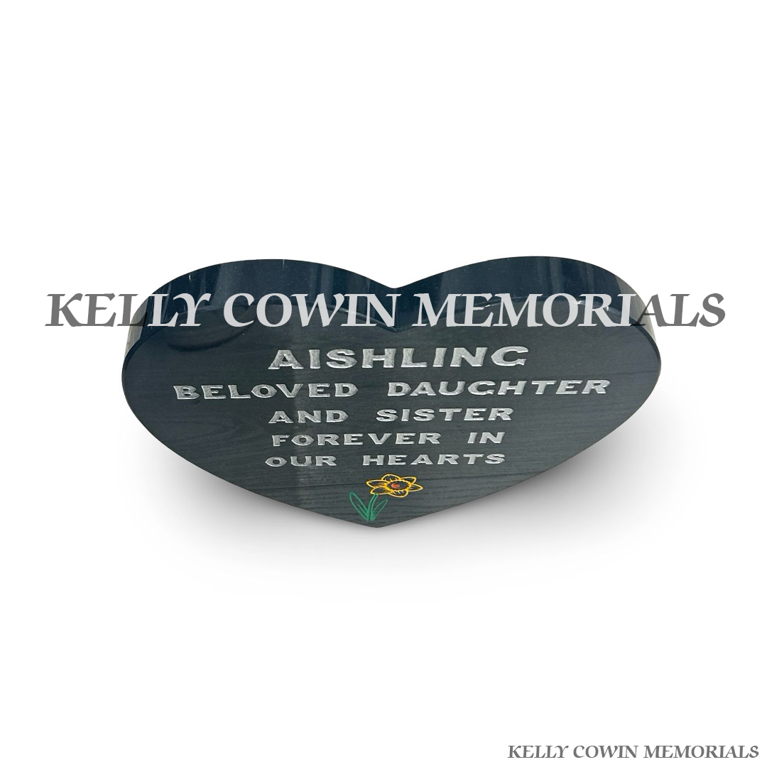 Close-up of colour daffodil engraving and silver lettering on granite plaque