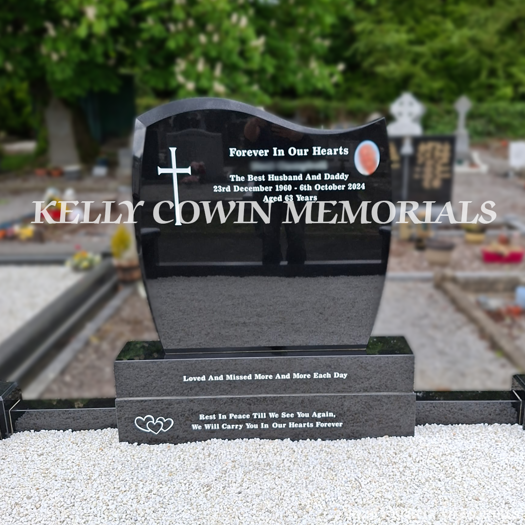 Close-up of white engraved inscription and ceramic photo on black granite headstone