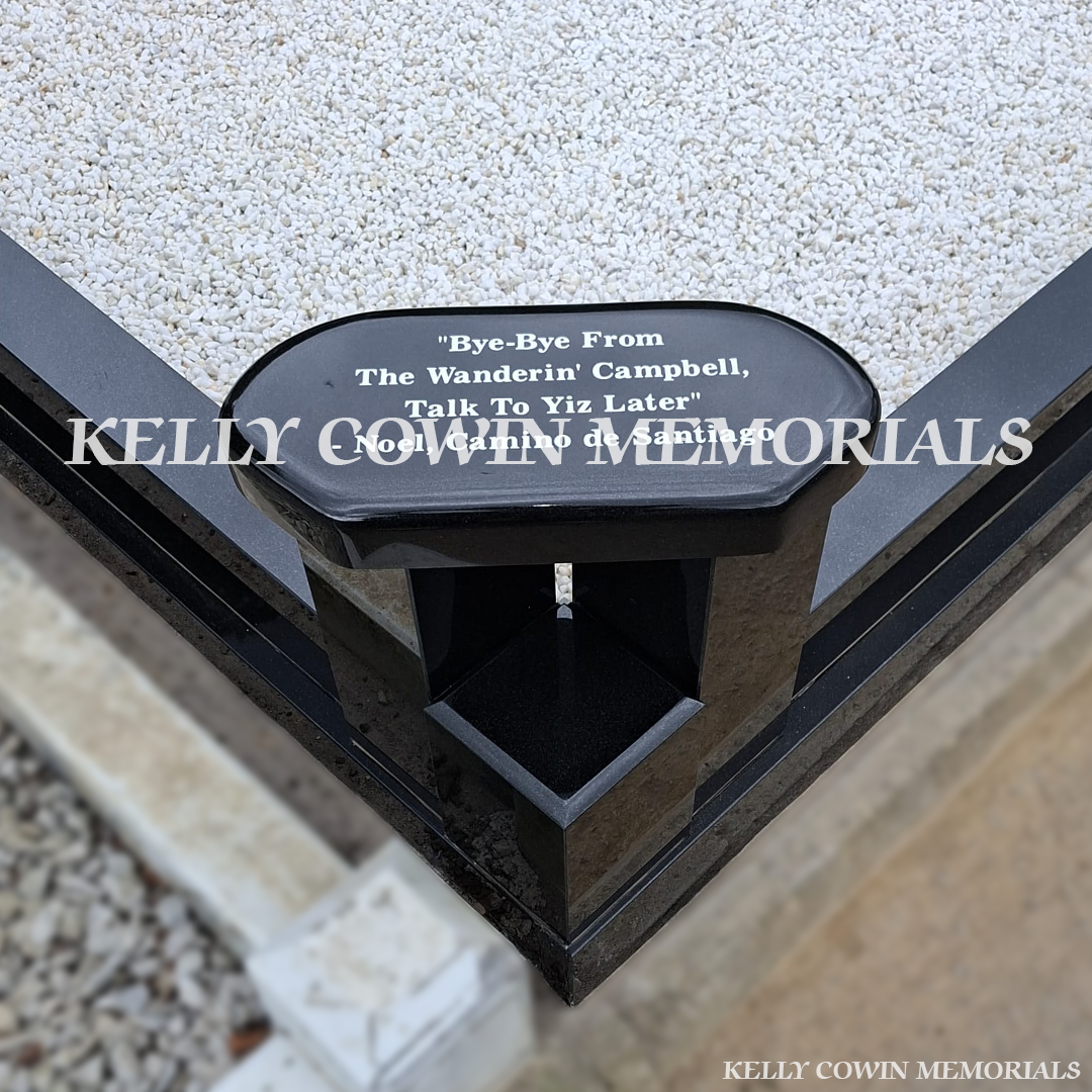 Close-up of white engraved inscription on black granite bench 