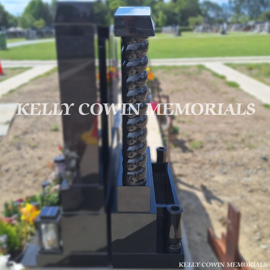 Side view of Black granite Gates of Heaven headstone with twisted pillars, granite cap installed in Balgriffin Cemetery Dublin by Kelly Cowin Memorials.