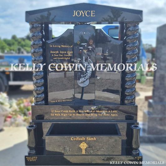 Black granite Gates of Heaven headstone with twisted pillars, granite cap, laser-etched photo, gold leaf inscription, flower box and twin vases installed in Balgriffin Cemetery Dublin by Kelly Cowin Memorials.