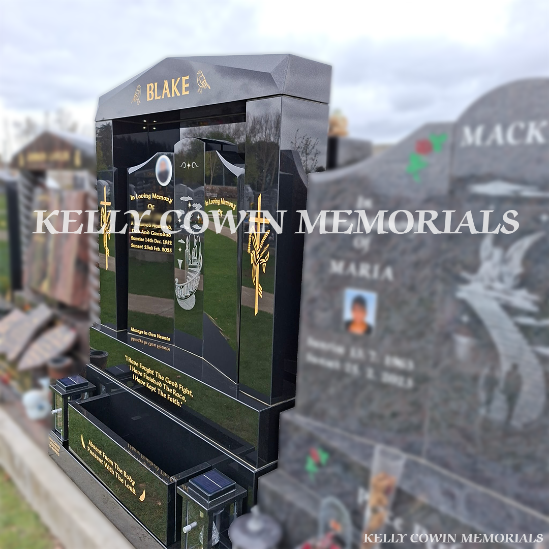 Side view of black granite memorial with pillars, lanterns and flower box