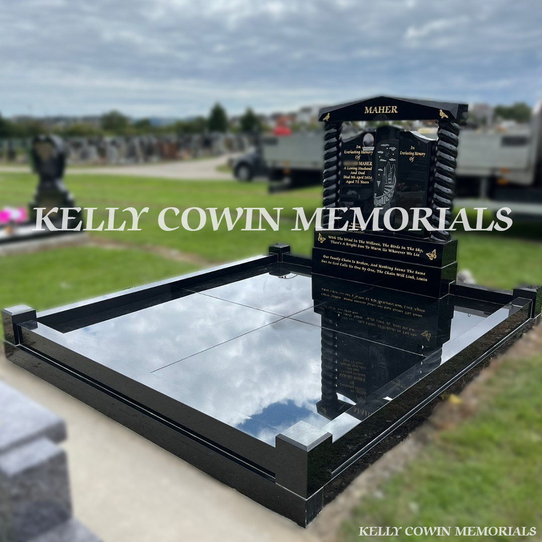 Side view of black granite memorial with twisted pillars and full kerbing