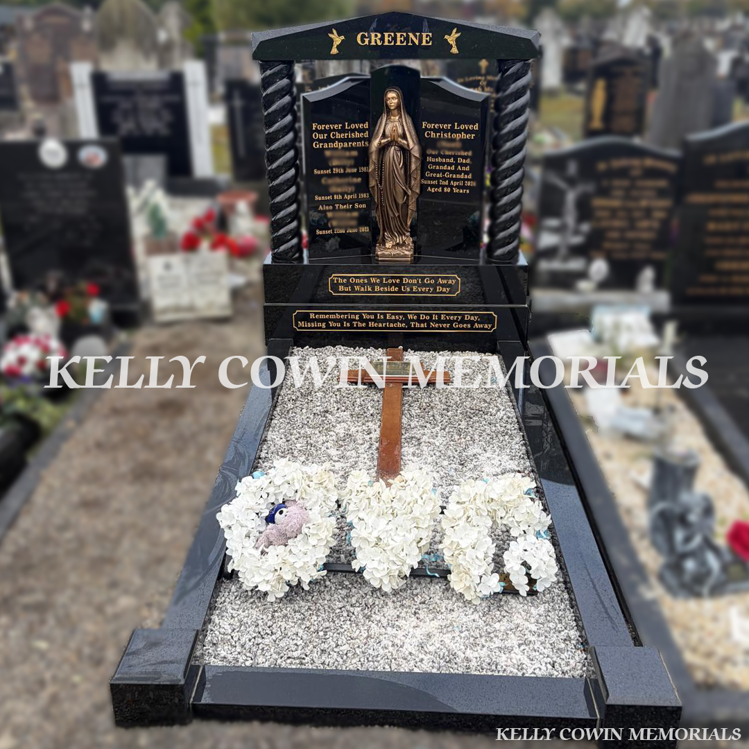 Black granite Gates of Heaven double plot headstone with gold engraving, decorative cap, twisted pillars, sub-base, base, bronze Our Lady statue, full grave kerbing and grey-white chippings, erected in Glasnevin Cemetery, Dublin, by Kelly Cowin Memorials.