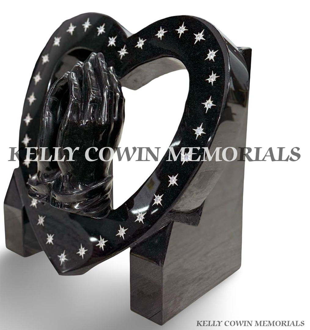 Custom-designed black granite praying hands heart memorial with silver engraved stars, available from Kelly Cowin Memorials.