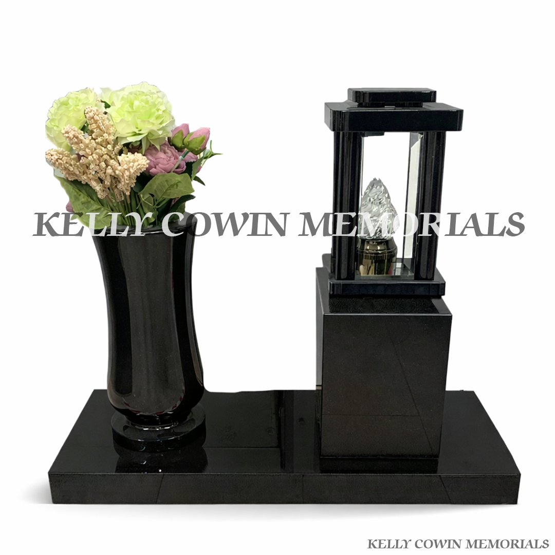 Front view of black granite lantern and matching vase on plinth with artificial flowers