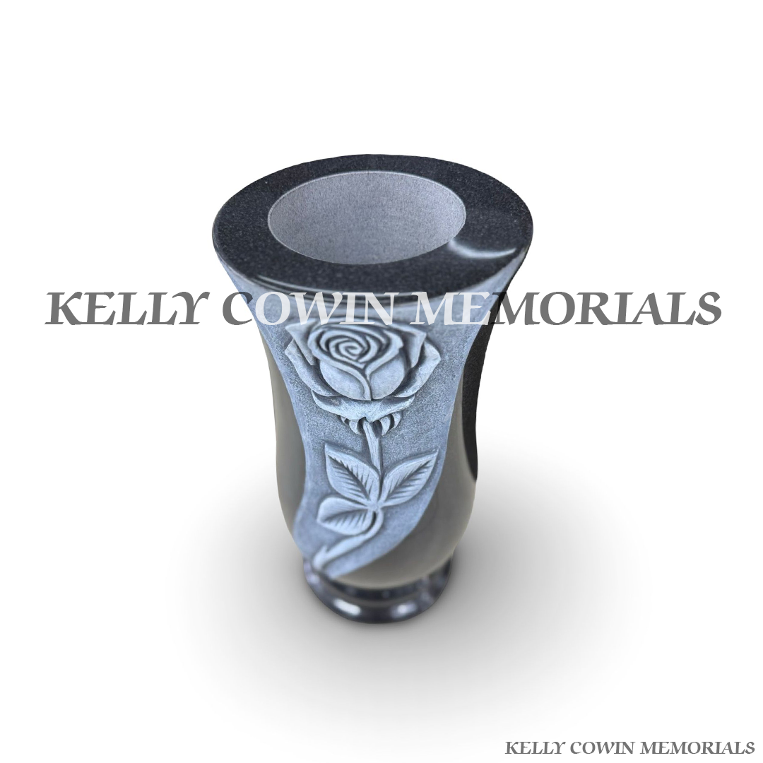 Close-up of antique carved rose detail on black granite vase