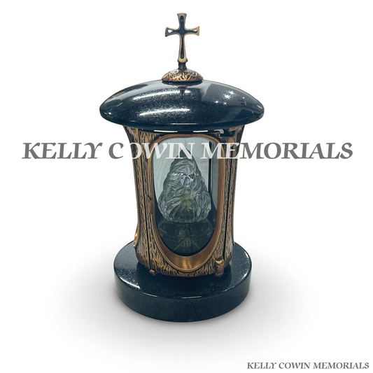 Front view of black granite round lantern with bronze cross and door