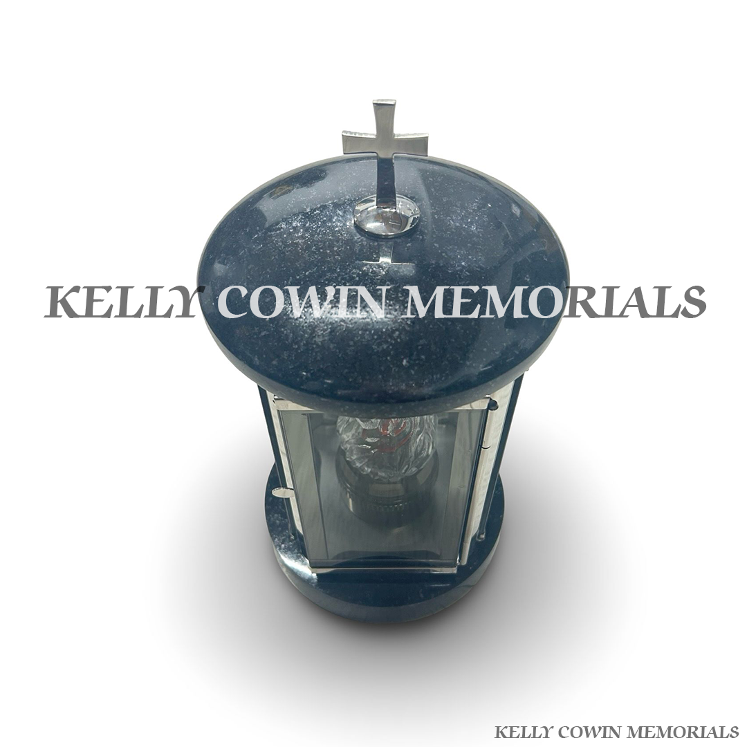 Close-up of silver cross detail on top of black granite lantern