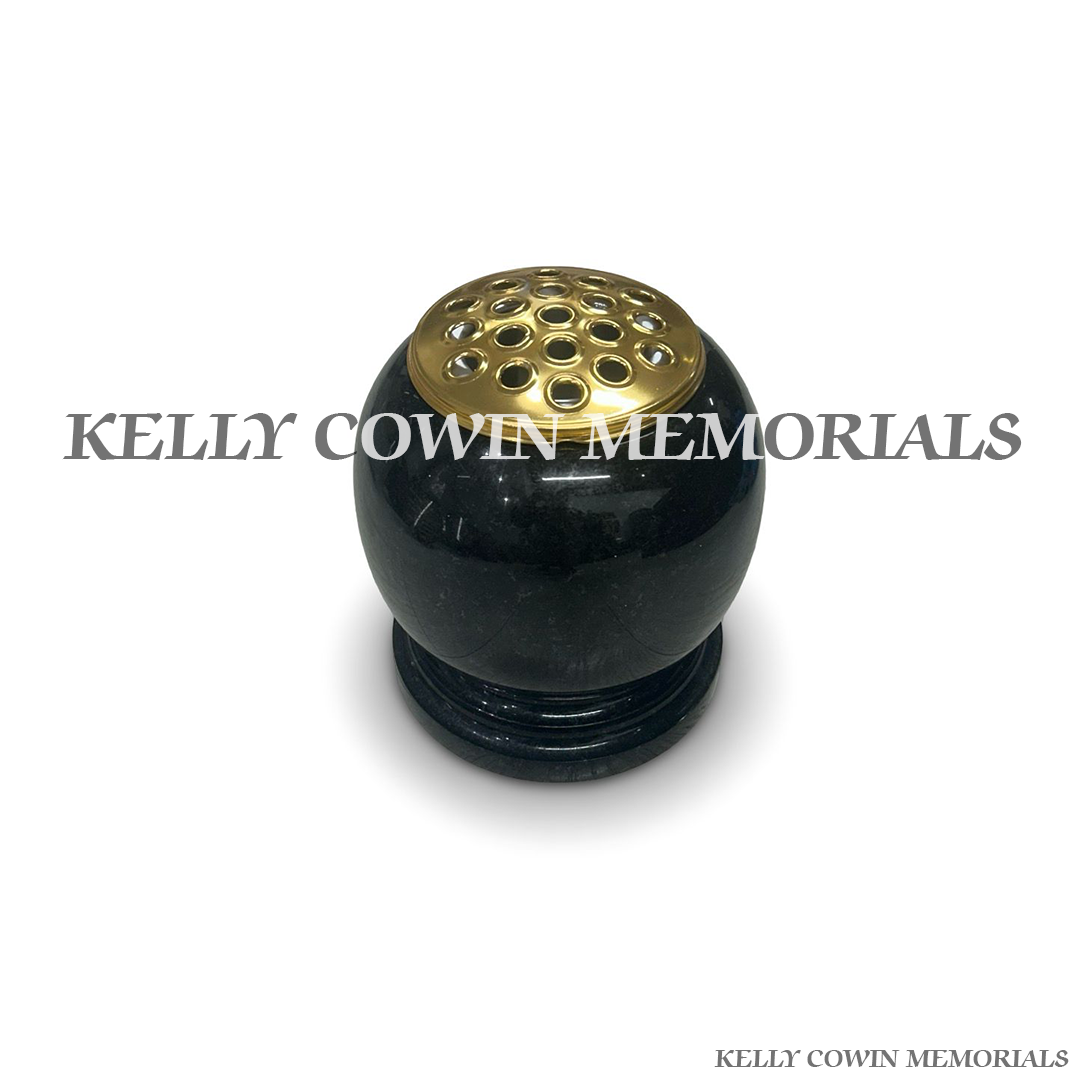 Close-up of gold lid on black granite urn shaped vase