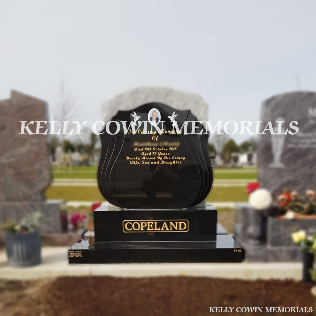 Front view of black granite shell shaped headstone with gold inscription in Balgriffin Cemetery