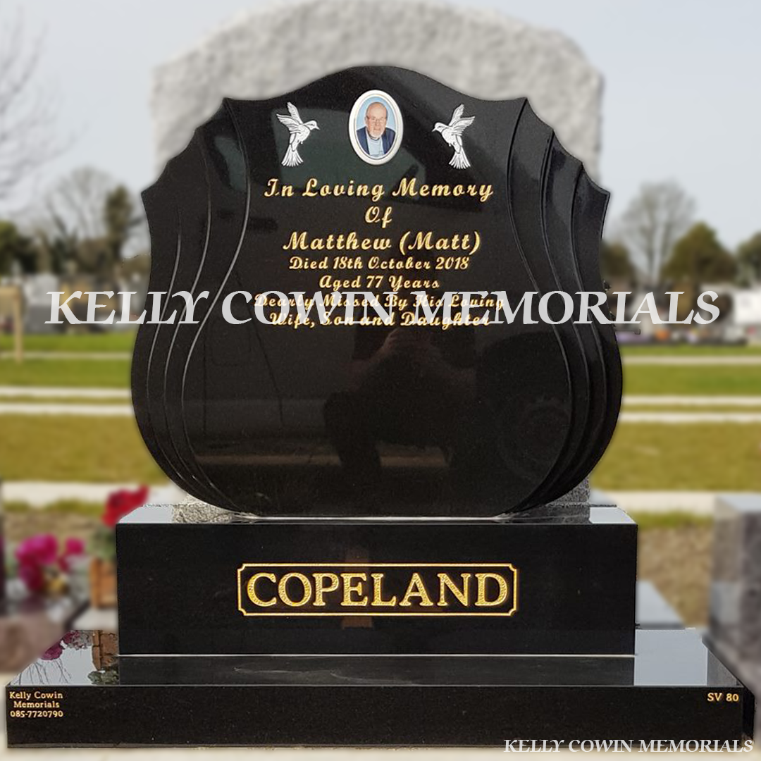 Front view close up of black granite shell shaped headstone with gold inscription in Balgriffin Cemetery