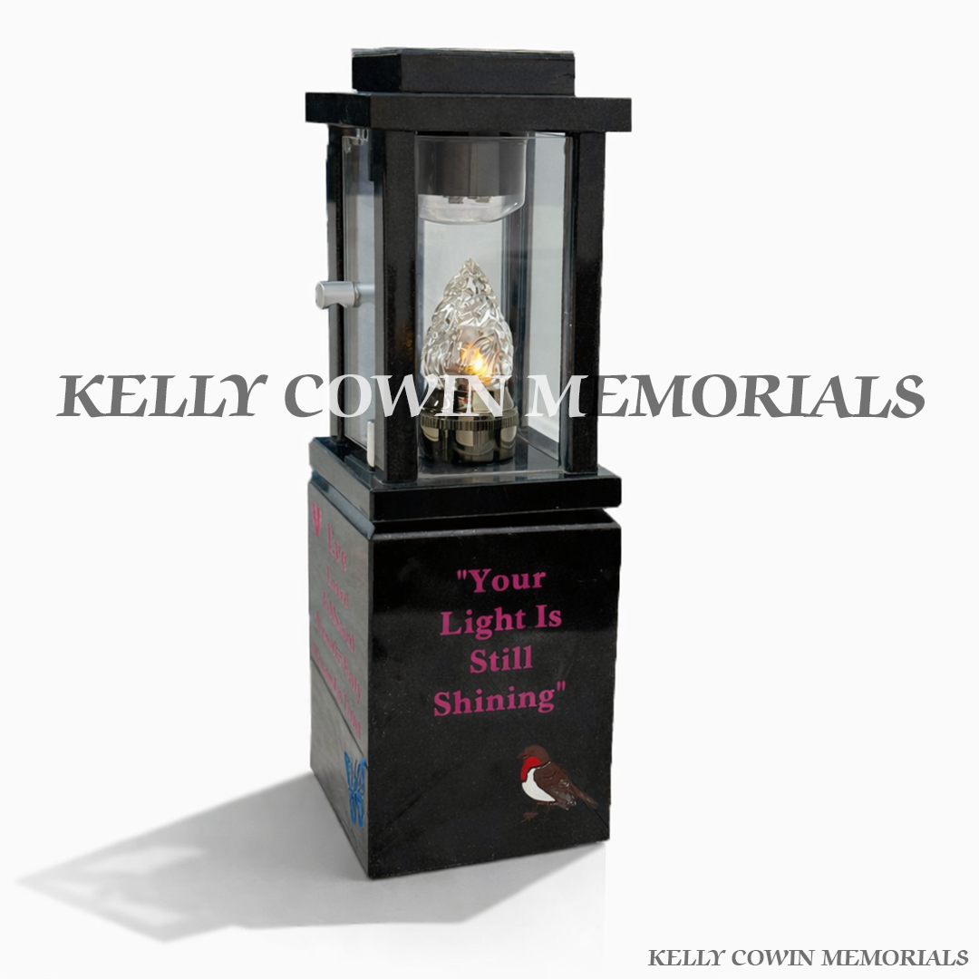 Side view of black granite lantern on engraved block with candle flame insert