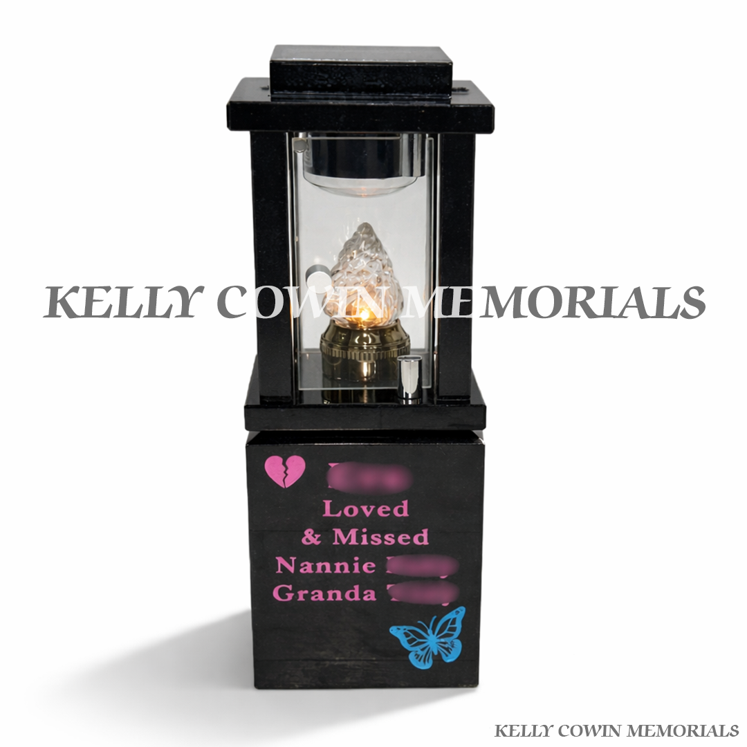 Front view of black granite solar lantern with pink engraving and symbolic images