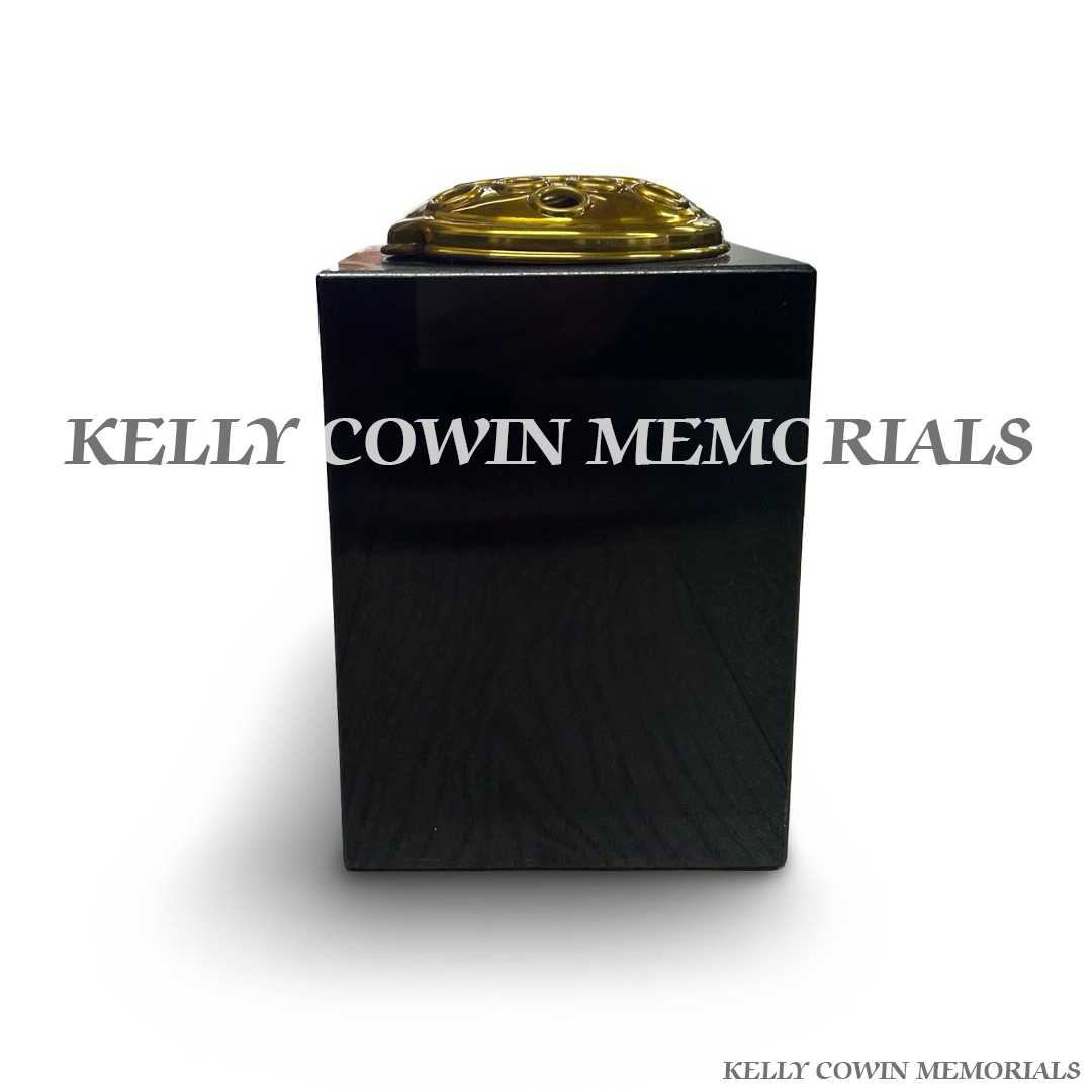 Back view of polished black granite square vase with gold lid