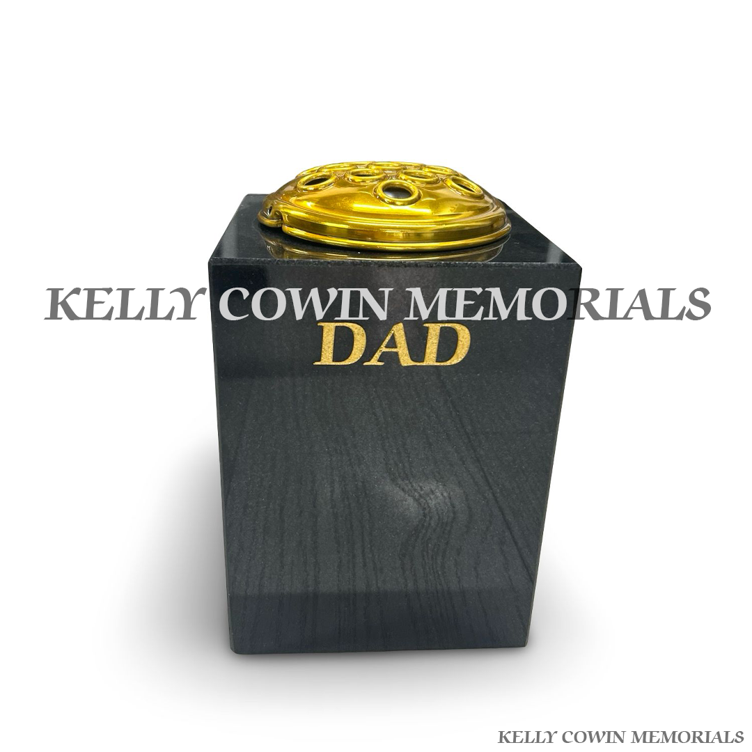 Front view of black granite square vase with gold lid and gold inscription