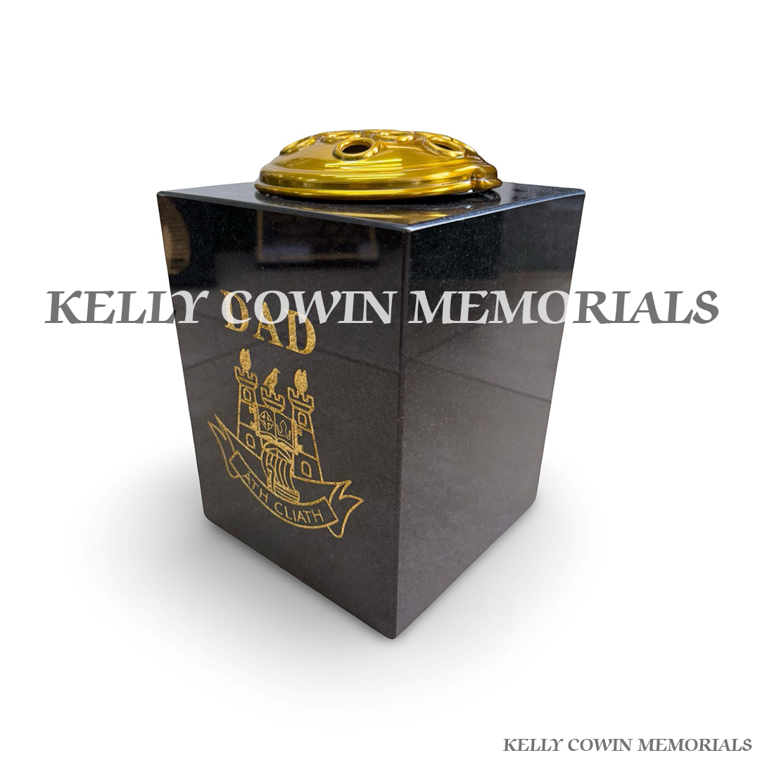 Side view of polished black granite square vase with gold engraving
