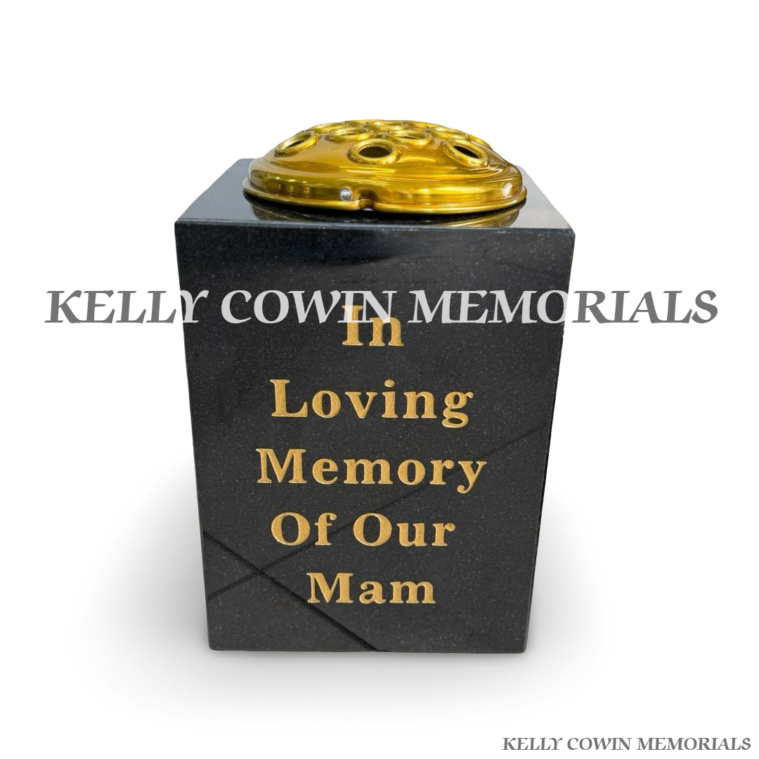 Front view of black granite square vase with gold lid and gold inscription