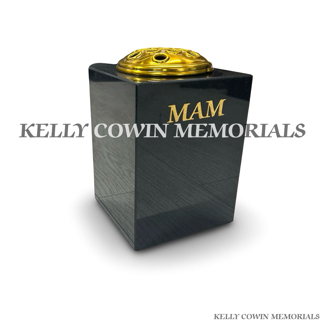 Side view of polished black granite square vase with gold lid