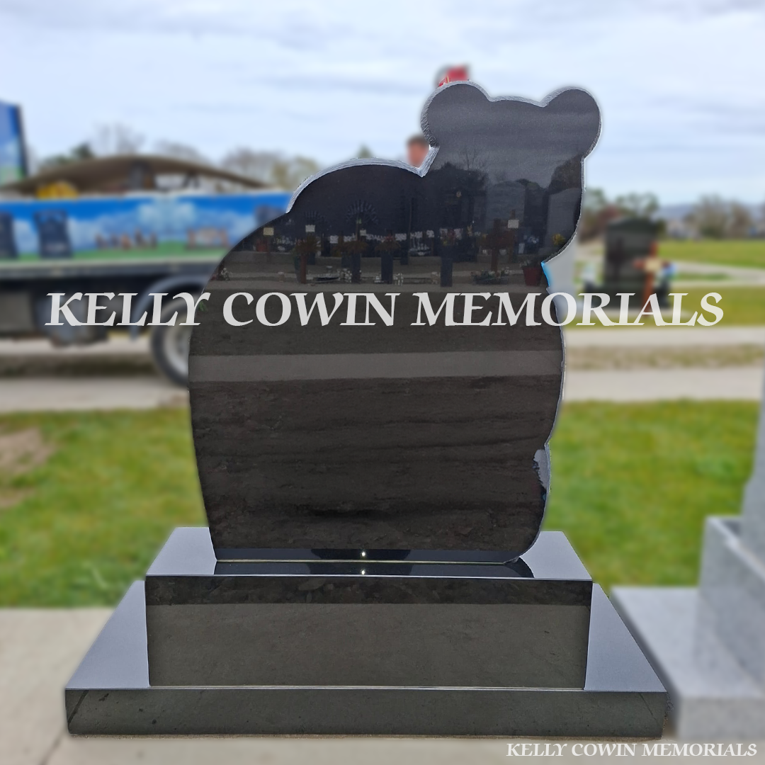 Back view of black granite teddy bear children’s headstone with blue detailing in Balgriffin Cemetery