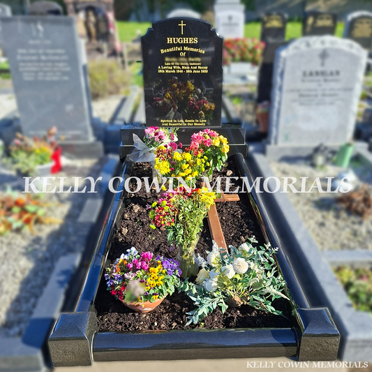 Black granite Top Nine headstone with traditional shaped top, personalised gold inscription, matching rounded granite grave kerbing, decorative corner posts and colourful floral arrangements, erected in Esker Cemetery, Dublin, by Kelly Cowin Memorials.