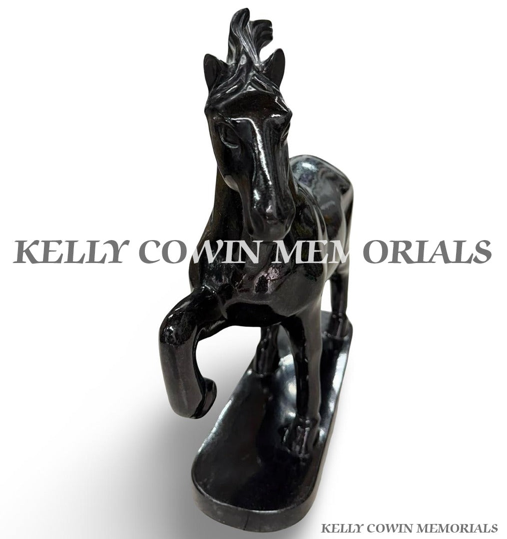 Front angled view of polished black granite horse memorial ornament with detailed carving and freestanding base.