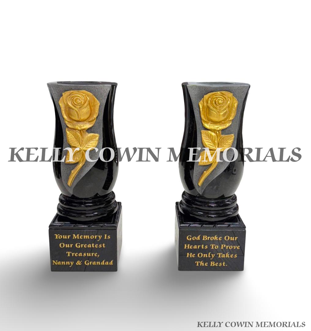 Matching pair of black granite memorial vases with gold carved roses, engraved blocks and rope detailing.
