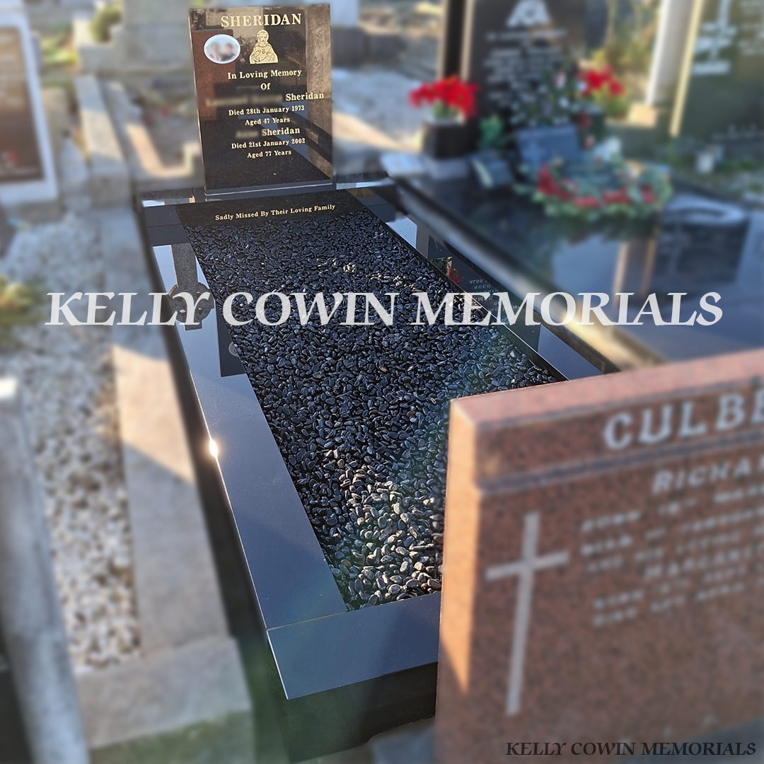 Side view of black granite memorial with kerbing and black chippings