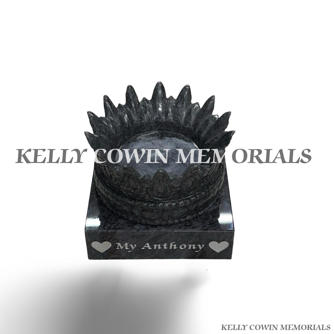 Close-up of intricately carved Blue Lagoon granite crown grave accessory.