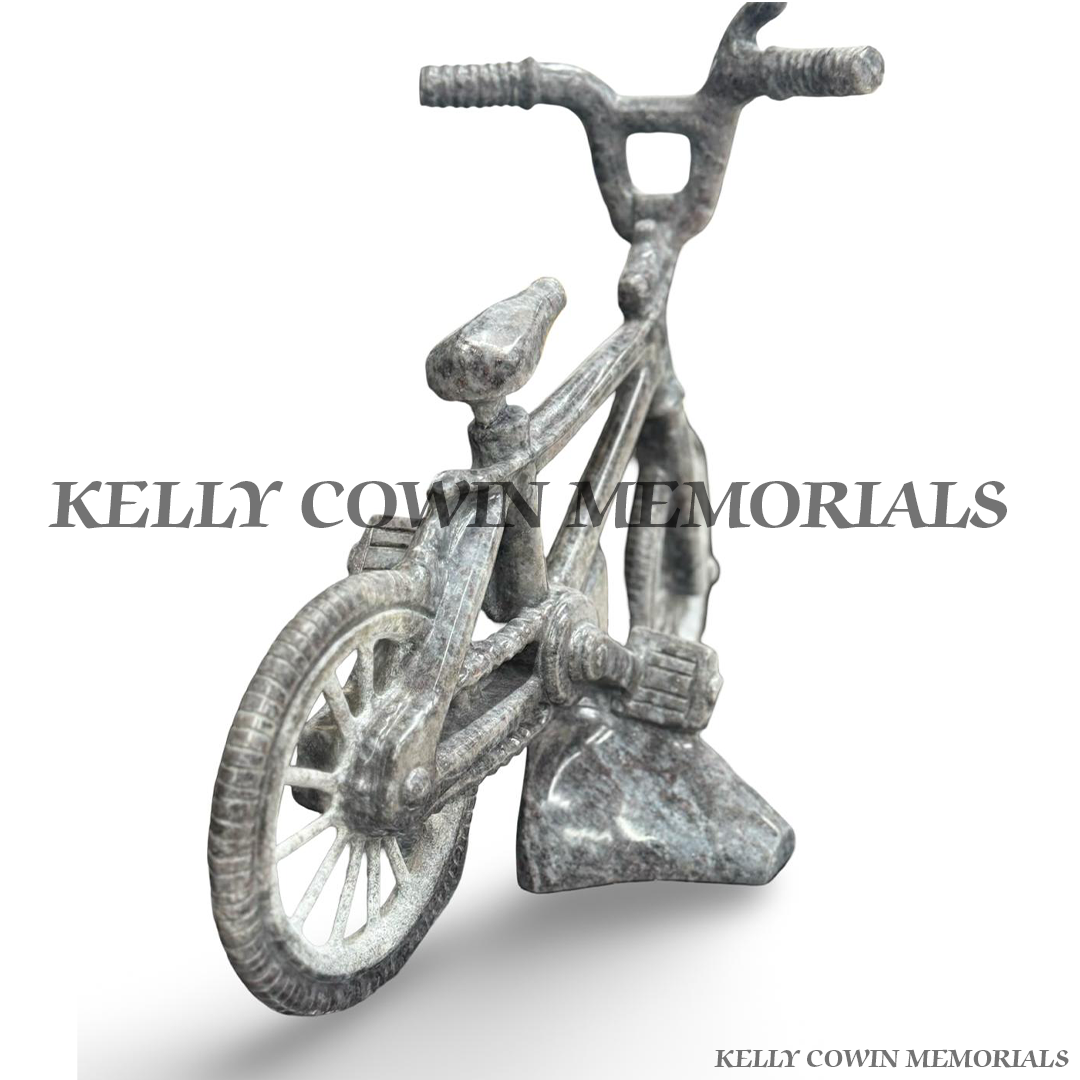Custom Blue Lagoon granite child’s bicycle memorial ornament with detailed wheels, handlebars, pedals and granite support.
