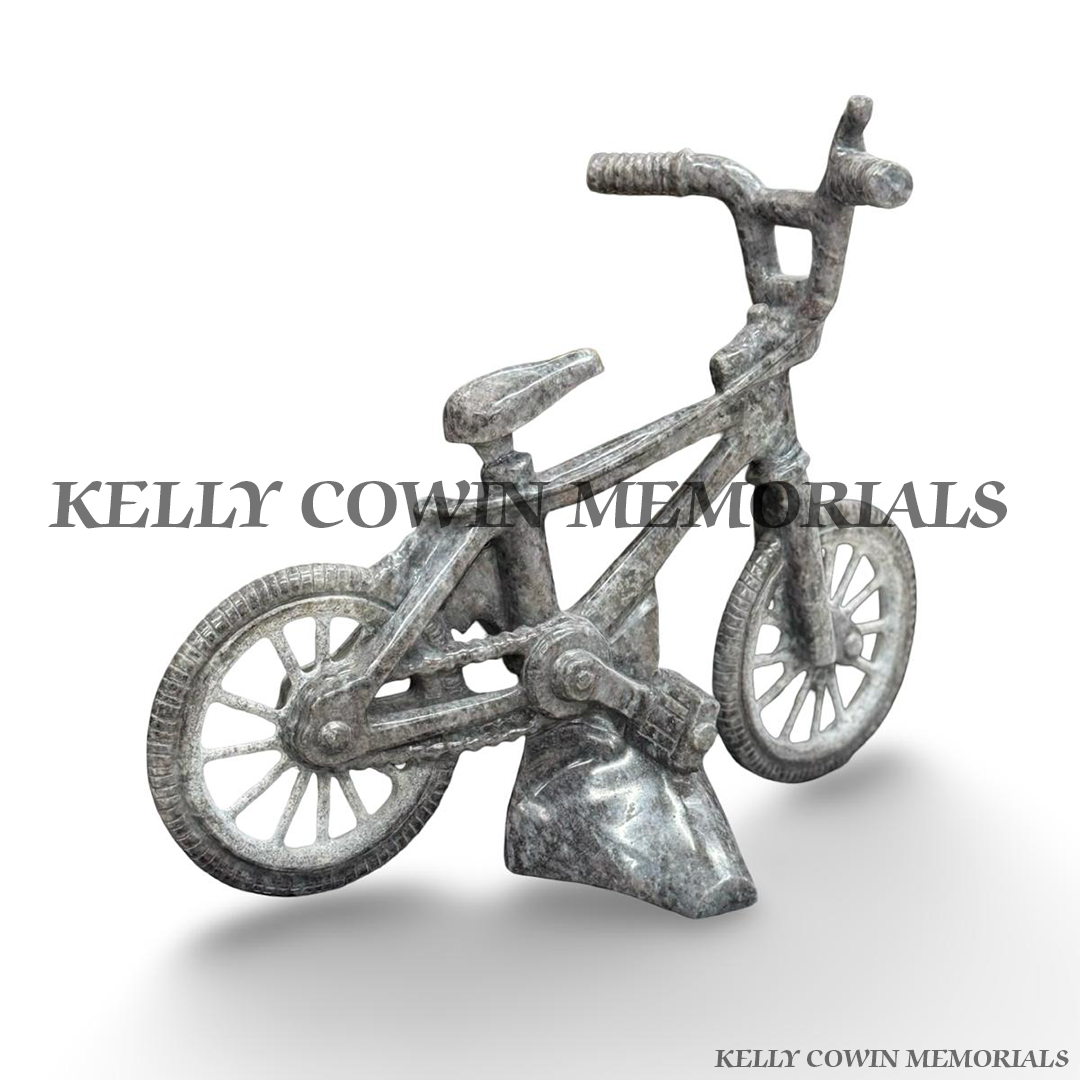 Side view of custom-made Blue Lagoon granite child’s bicycle memorial ornament showing detailed frame, wheels and pedals.