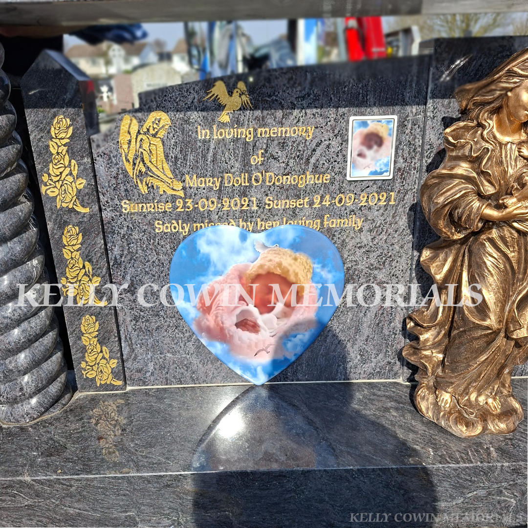 Close-up of gold leaf inscription and detailed statues on Blue Lagoon headstone
