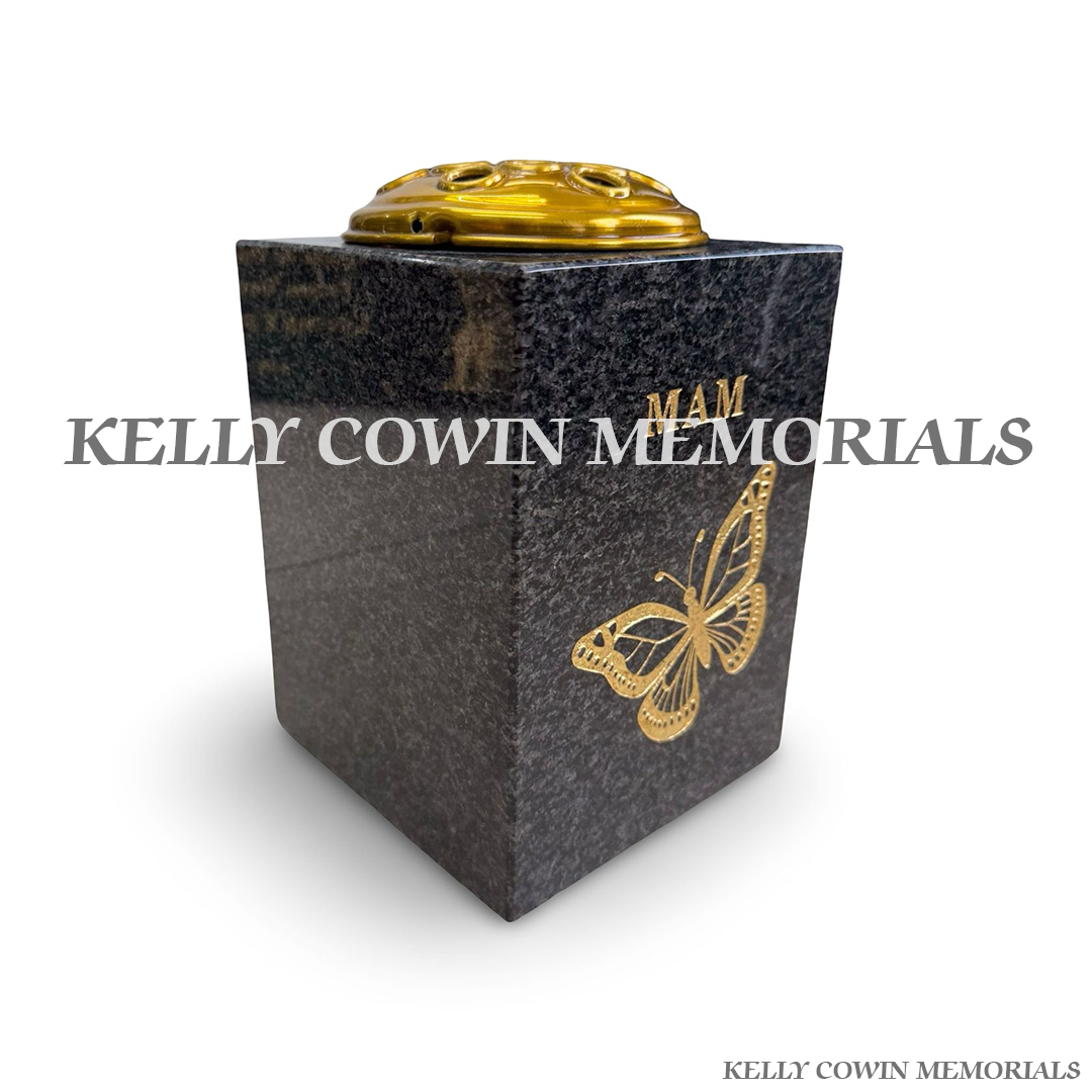 Side view of polished Blue Lagoon granite vase with gold lid and engraving