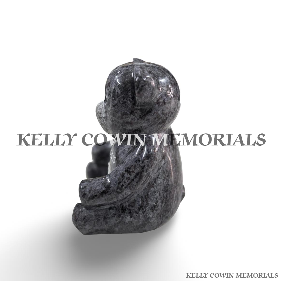 Blue Lagoon granite teddy bear grave ornament photographed from the opposite side, displaying its smooth polished granite surface and three-dimensional seated shape.