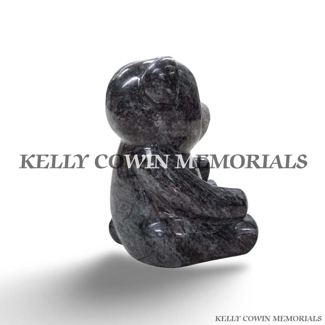 Side view of handcrafted Blue Lagoon granite teddy bear memorial featuring a polished finish, rounded body, carved paws and detailed seated design.