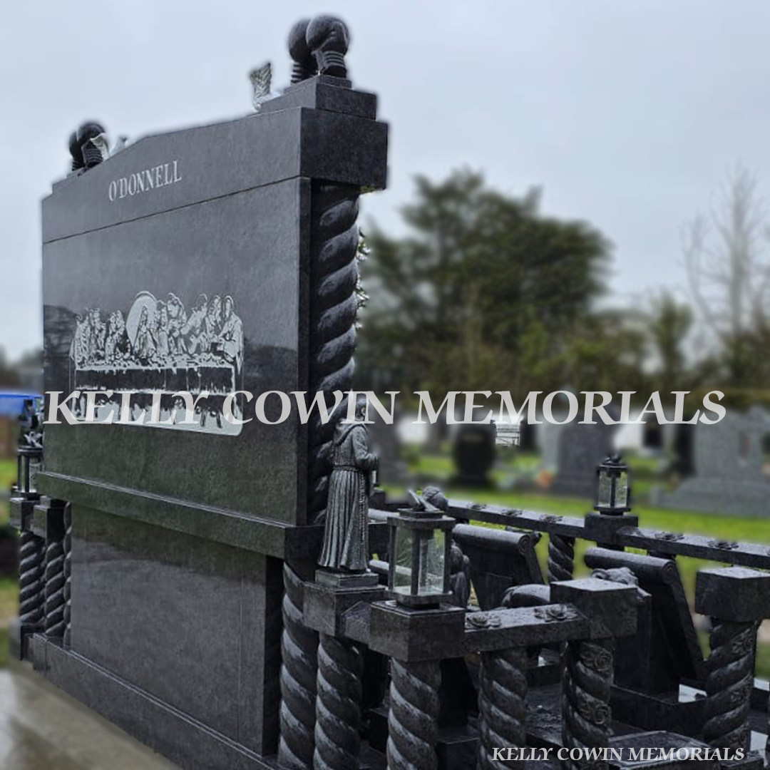 Rear-side view of custom Blue Lagoon headstone with Last Supper engraving and granite statues – Kelly Cowin Memorials