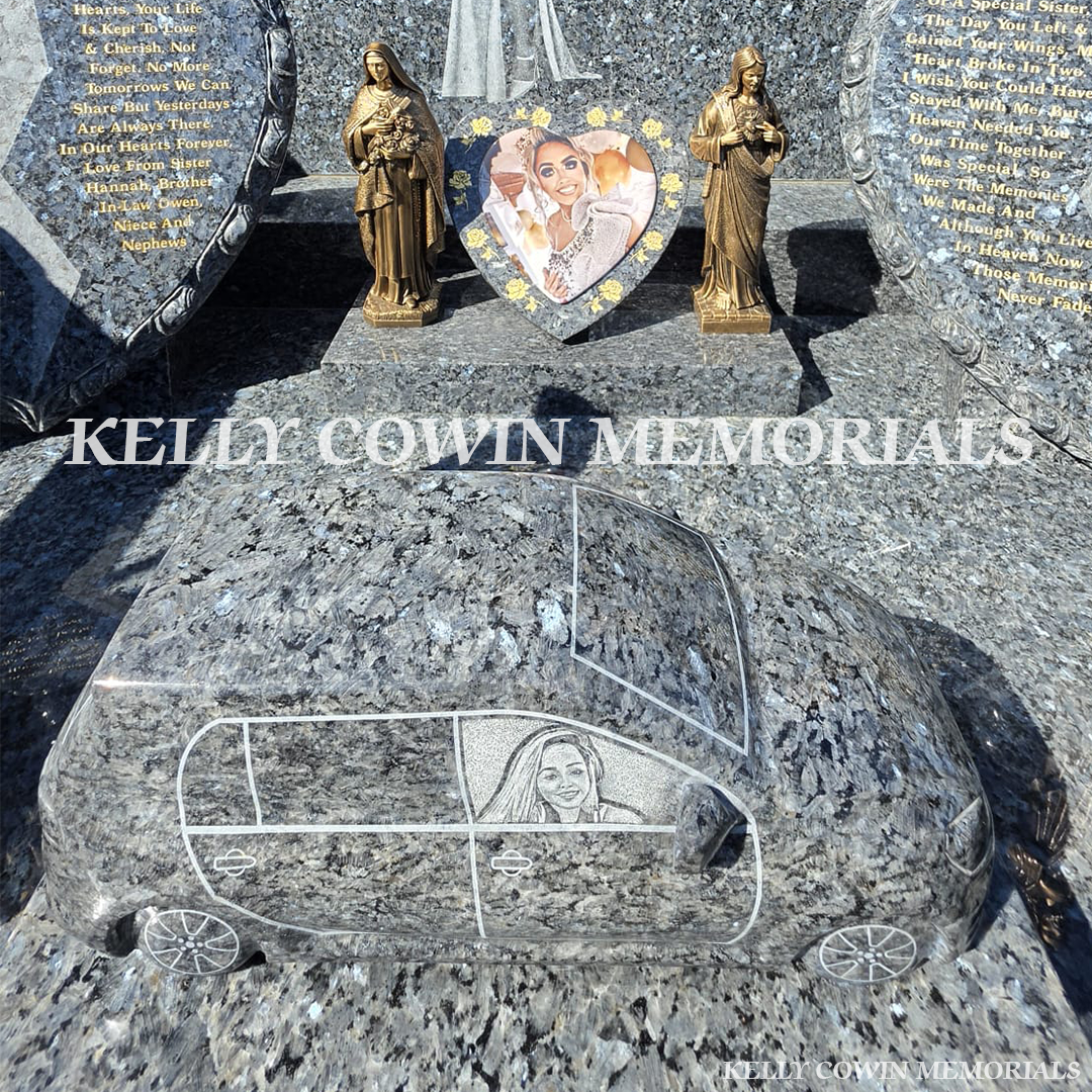 Close-up of Blue Pearl car on plinth and 14" heart with ceramic photo and x2 bronze statues 