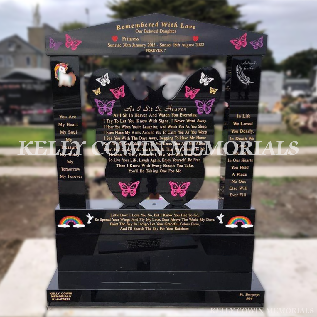Black granite butterfly children’s headstone with a cap and pillars and coloured inscription in Balgriffin Cemetery Dublin