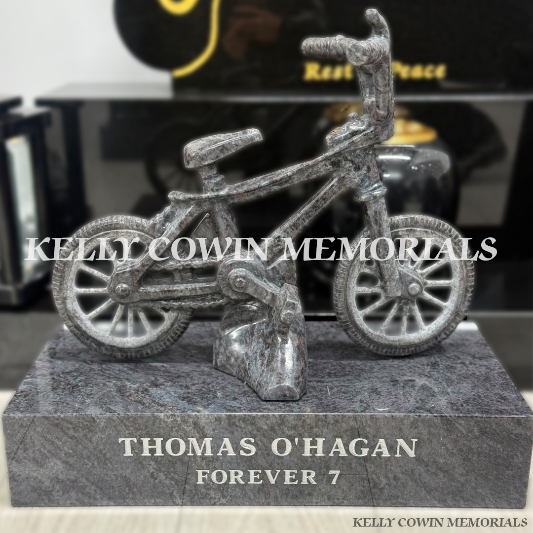 Custom Blue Lagoon granite child’s bicycle mounted on a polished granite memorial base with personalised silver inscription.