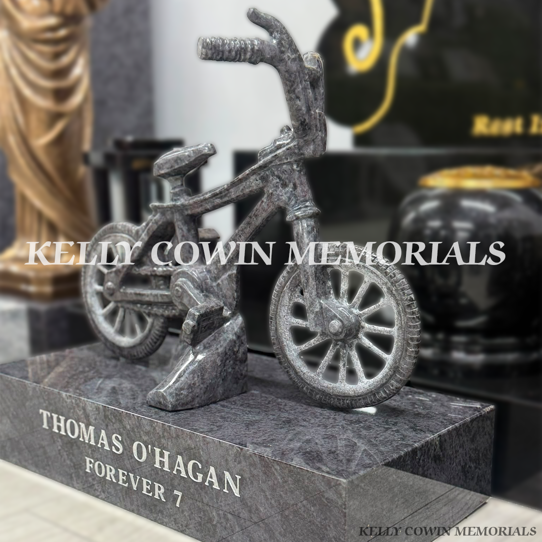 Close-up of handcrafted Blue Lagoon granite bicycle memorial showing detailed handlebars, wheel, frame and polished finish.