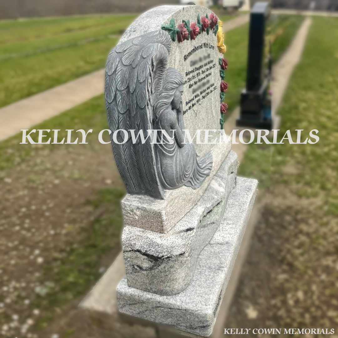 Side view of grey granite angel boulder headstone on base and plinth in a Dublin cemetery